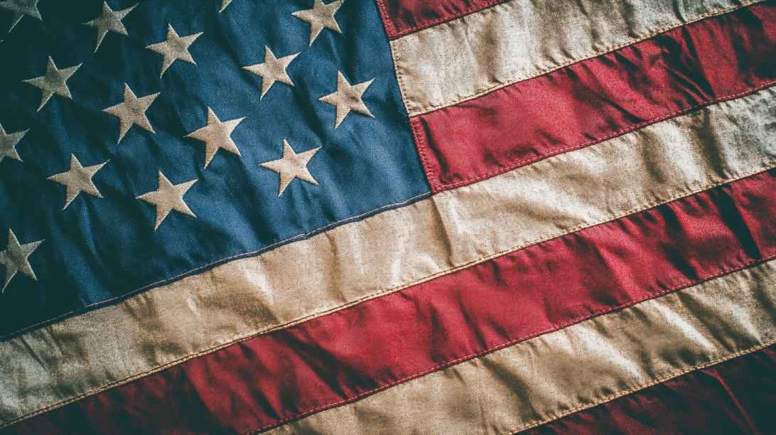 Close-up of a weathered American flag with visible stars and stripes