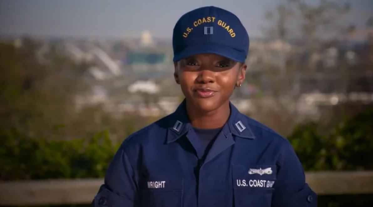 U.S. Coast Guard Reserve officer in uniform smiling outdoors with cityscape in the background