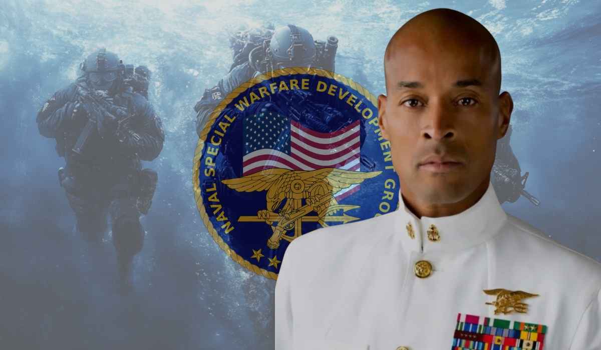 David Goggins in white Navy SEAL uniform standing in front of a Naval Special Warfare Development Group emblem and underwater SEAL team background