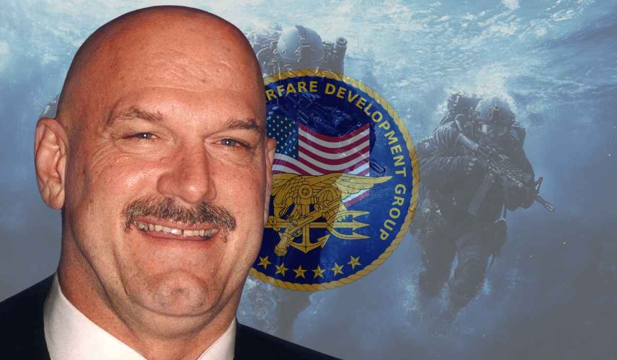 Jesse Ventura smiling in a suit with a Naval Special Warfare emblem and underwater SEAL team background