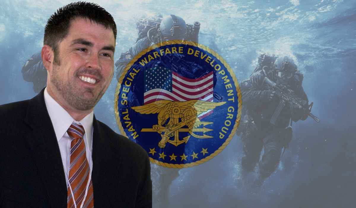 Marcus Luttrell in a suit with Navy SEAL emblem and underwater SEAL team background