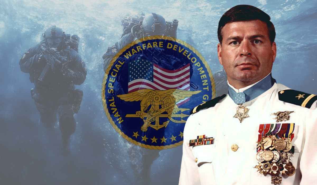 A decorated U.S. Navy SEAL in dress uniform stands before the Naval Special Warfare Development Group emblem with underwater SEALs in the background.