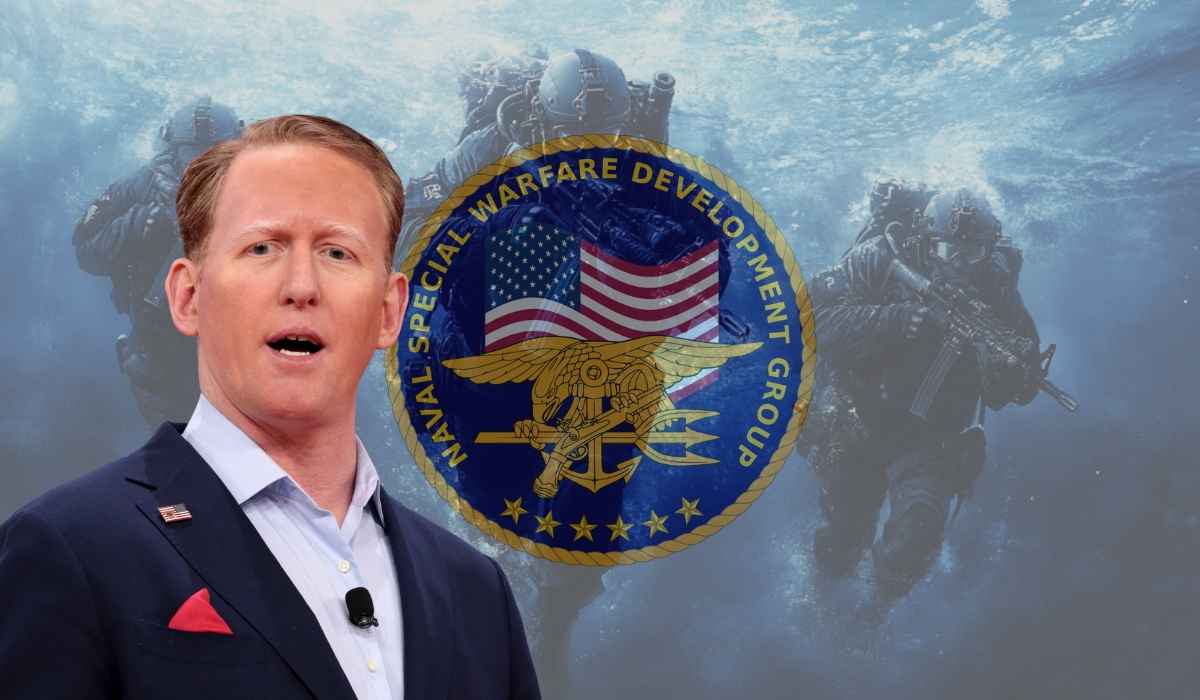 Rob O’Neill speaking in front of a Navy SEALs emblem background, with underwater special ops soldiers behind him