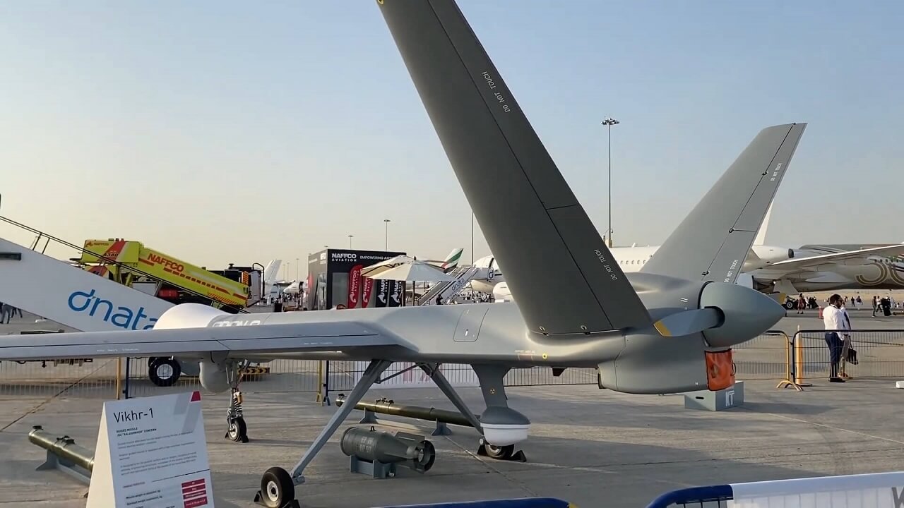 Rear-side view of the Kronshtadt Orion UAV on display at an airshow, equipped with surveillance gear and Vikhir-1 guided missile system