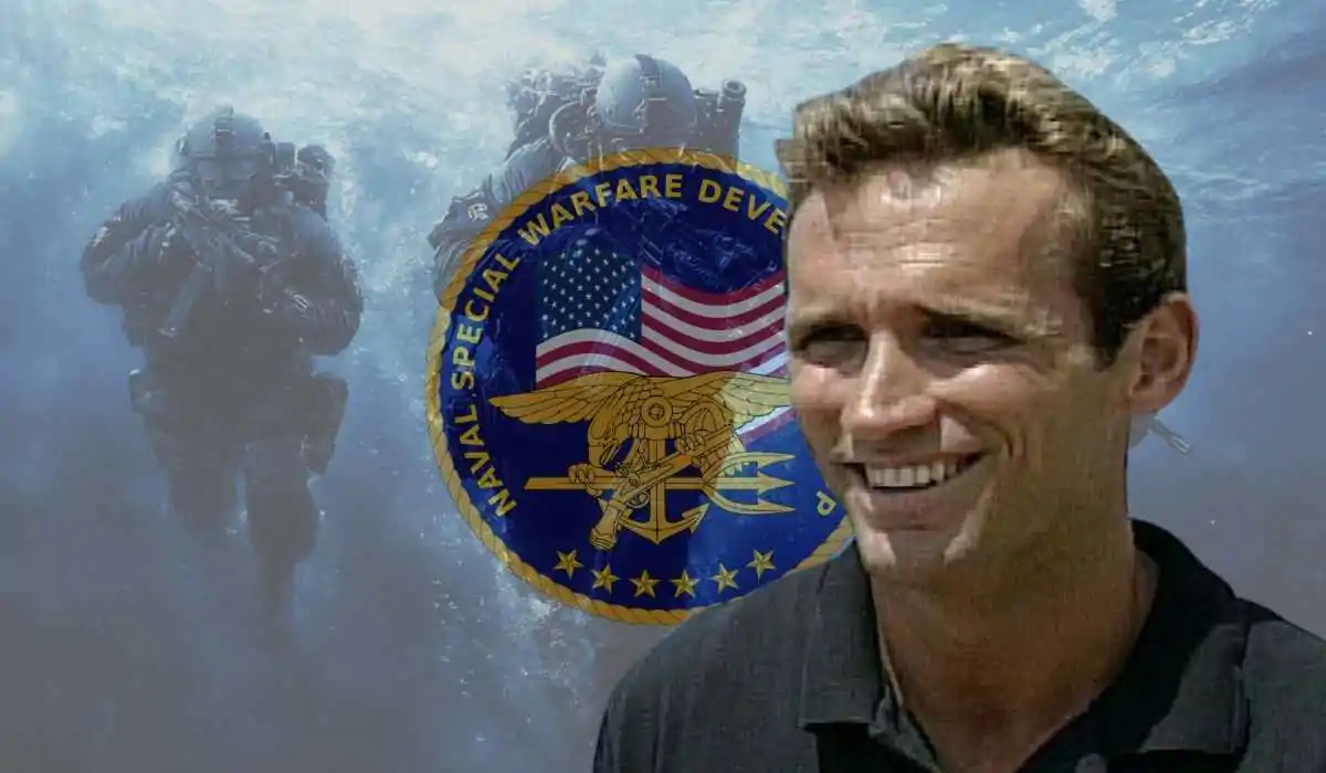 Scott Helvenston smiling in front of a Navy SEALs underwater team and Naval Special Warfare emblem.