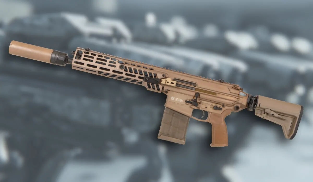 A tan-colored XM7 rifle with suppressor and modular handguard, displayed against a blurred background of firearms