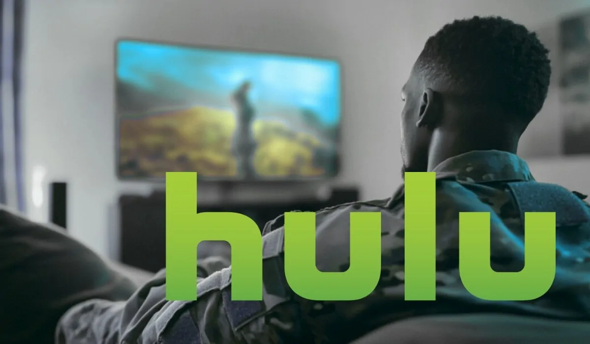 A person in military uniform watches television in a living room, with the Hulu logo prominently displayed