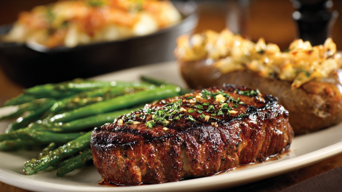 Juicy grilled steak served with green beans and a loaded baked potato on a dinner plate