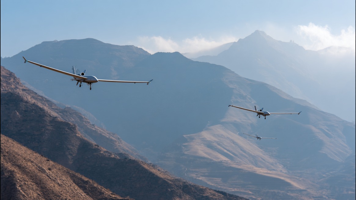 Three Iranian military drones flying over mountainous terrain during daylight, demonstrating surveillance or operational maneuver
