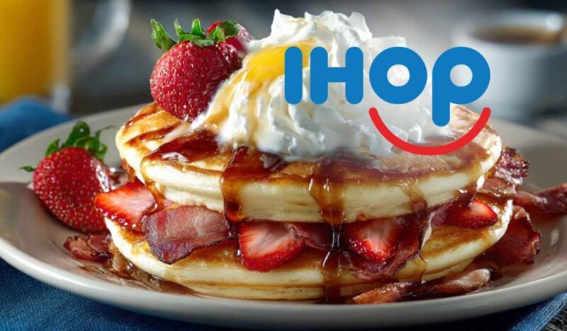 Fluffy IHOP pancakes stacked with strawberries, bacon, syrup, and whipped cream, symbolizing IHOP’s free meal offer for veterans and military members